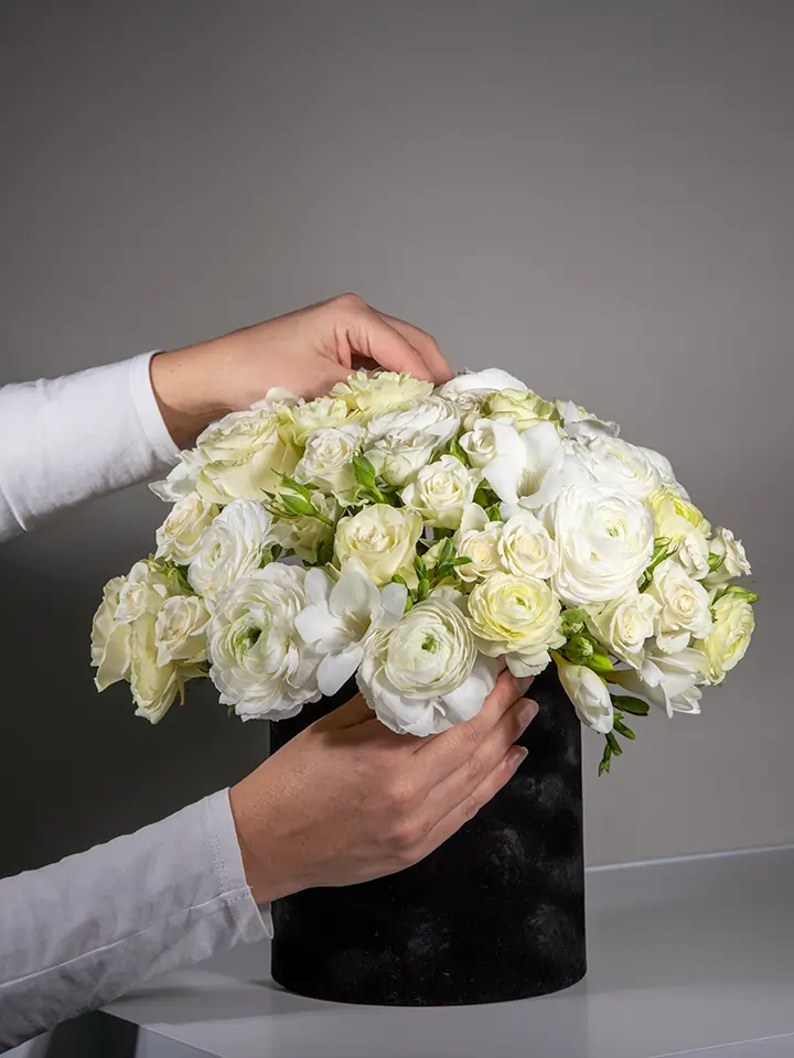 Flower box nera di fiori bianchi in mano